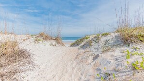 A sandy beach path leading to the sea with sparse vegetation. - Sol Mate-Elevator,Beach,Firepit rooftop,Arcade (St. Augustine)