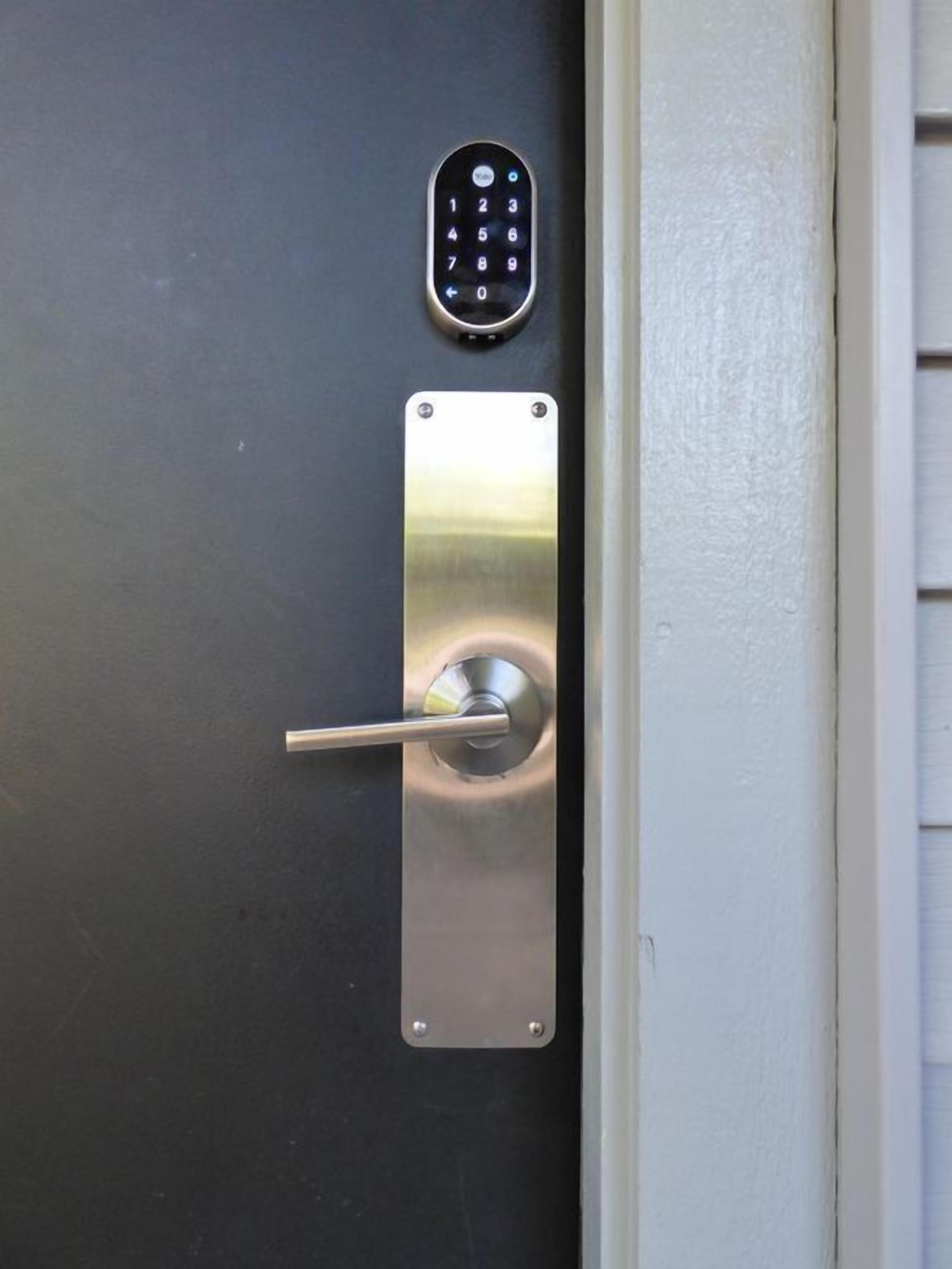 A door with a keyhole and a keypad lock.