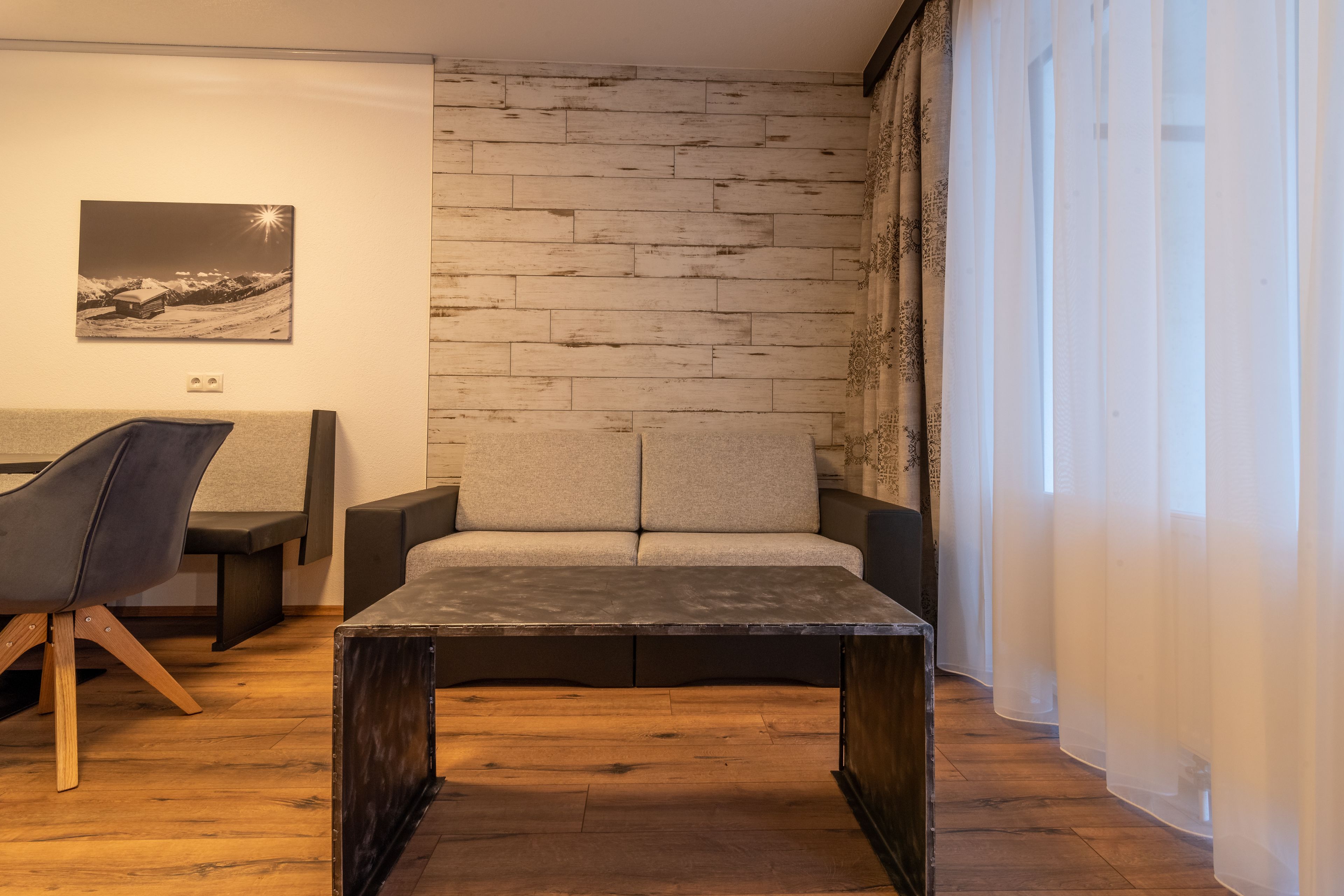 A modern living room with a sofa, a coffee table, and a chair.