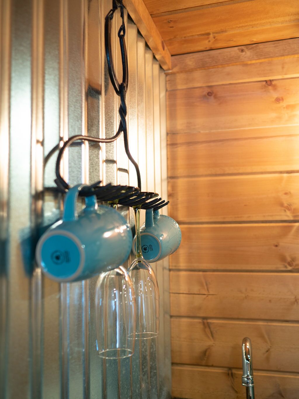 Een keuken met houten wanden, een hanglamp en een kraan.