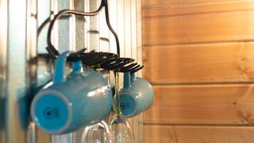 Een keuken met houten wanden, een hanglamp en een kraan.