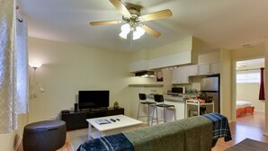 A compact living space with a kitchenette, a dining area, and a TV.