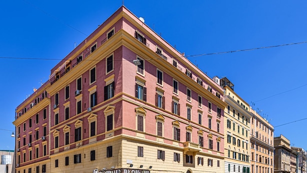 A multi-story building with a pink facade and yellow trim.