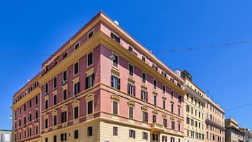 A multi-story building with a pink facade and yellow trim.