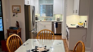 A modern kitchen with white cabinets, a built-in oven, and a window with blinds. - NEWLY RENOVATED, Nicely Equipped, Steps to the Beach, Perfect for Families (Hilton Head Island)
