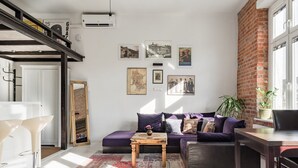 A modern living room with a sofa, coffee table, and artwork on the wall.