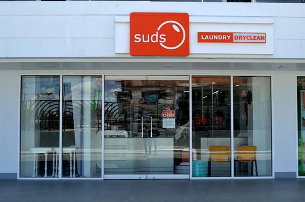 A storefront with a sign reading "suds laundry dryclean."