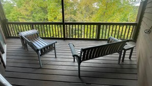 A wooden deck with two benches and a railing, overlooking a forested area. - Winterplace Condo E306 (Ghent)