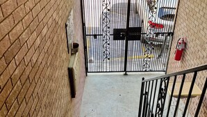 A staircase leading to a gated parking area.