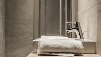 Ein Badezimmer mit einem modernen Waschbecken, einem Handtuch und einem Spiegel.