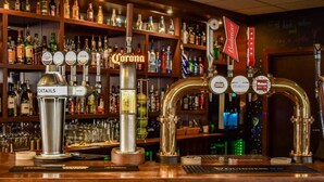 Un bar con varias griferías, incluyendo Corona, Budweiser y Guinness.