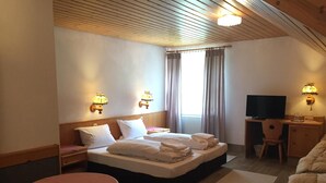 A hotel room with a bed, a desk with a chair, a television, and two wall-mounted lamps. - Alte Rose Gasthaus Hotel (Ebelsbach)
