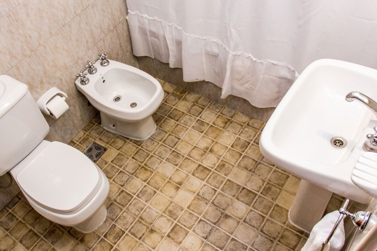A bathroom with a toilet, bidet, and sink.