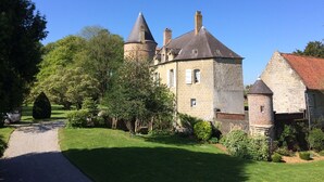 A historic building with a tower, a main building with a pitched roof, and a well-maintained garden. - cottage in the park of a castle(manor) (Wierre-Au-Bois)