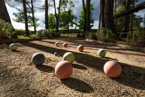 Ein Croquetfeld mit Kugeln und einem Holzzaun im Hintergrund.