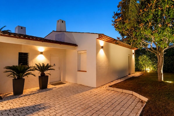 A house with a tiled roof, white walls, and a paved driveway. There are two potted plants and a tree in the yard. - 5* villa with private pool on prestigious estate (Villeneuve-Loubet)