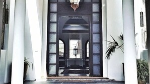 Una entrada imponente con un techo grande y ricamente decorado, y un candelabro central.