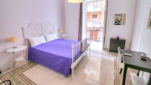 Un dormitorio con cama, mesitas de noche, escritorio y una silla.