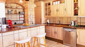 Una cocina moderna con un arco de ladrillo, armarios de madera, un lavavajillas de acero inoxidable y una cafetera.