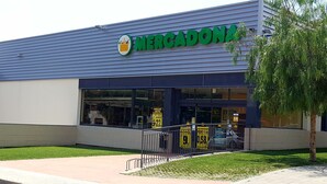 Un supermercado Mercadona con fachada azul, amplios ventanales y entrada visible.