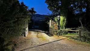 Un camino de grava que conduce a una entrada con puerta y un letrero que dice 'Castellet'.