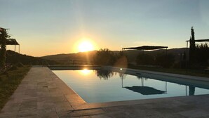 Una piscina con vistas despejadas al atardecer en el horizonte.