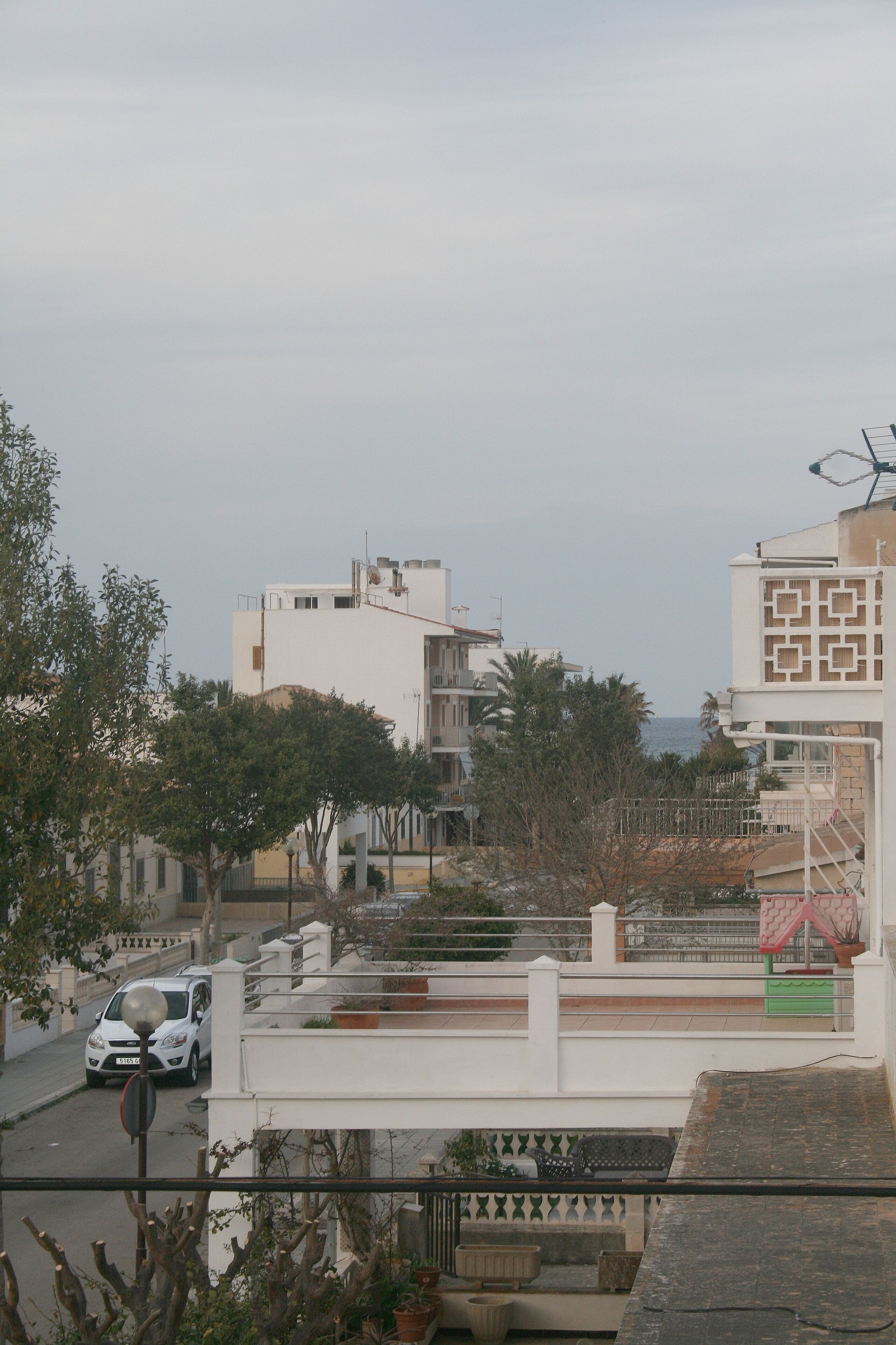 Zona residencial con edificios, una calle y un automóvil.