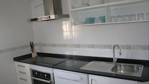 Uma cozinha equipada com lava-louças, fogão, pia e armários.