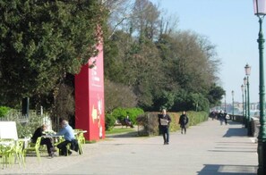 Un sendero en un parque con gente caminando y sentada en sillas.