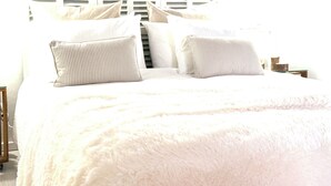 A bed with white bedding and striped pillows, a wooden nightstand, and a window with blinds. - Unique and charming apartment, in the historic center. Incomparable! (Santanyí)