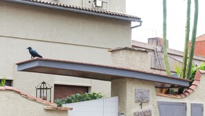 A building with a white door, a satellite dish, and a bird perched on the roof. - Spacious and bright apartment on the Costa Brava, landscape of the painter S. Dalí (Castelló d'Empúries)