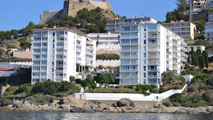 Ett hotell vid kusten med flera våningar, balkonger och utsikt över havet.