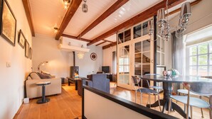 A spacious living area with a fireplace, a dining table with chairs, and a large window providing natural light.