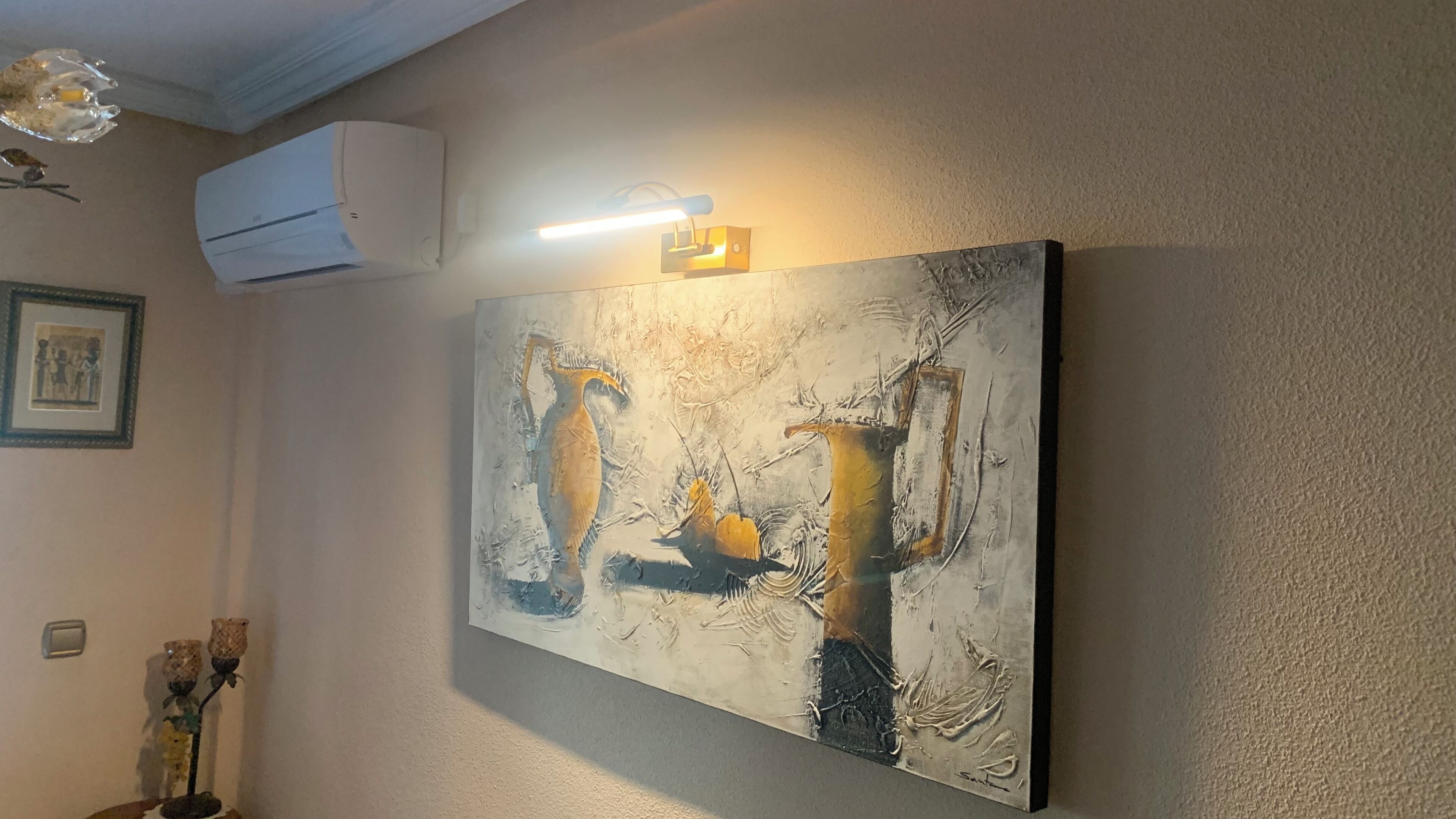Una pintura abstracta colgada en la pared, con superficie texturizada y pinceladas visibles.