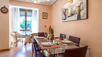 Een eethoek met een glazen tafel, stoelen en een ananas als decoratie.