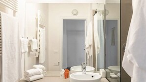 A modern bathroom with two sinks, a large mirror, and a towel rack with folded towels. - Residenza Torre Vecchiarelli - apt 4 (Roma)