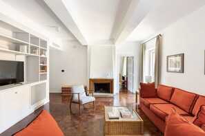 A spacious living room with a fireplace, a television, and a sofa. - Residenza Torre Vecchiarelli - apt 4 (Roma)