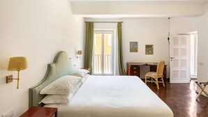 A hotel room with a bed, desk, chair, and a door. - Residenza Torre Vecchiarelli - apt 4 (Roma)
