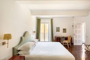 A hotel room with a bed, desk, chair, and a door. - Residenza Torre Vecchiarelli - apt 4 (Roma)