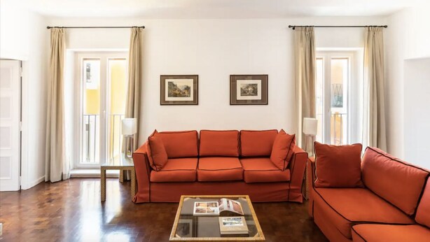 A living room with a red sofa, a glass coffee table, and two framed pictures on the wall. - Residenza Torre Vecchiarelli - apt 4 (Roma)