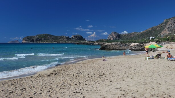 A beach with clear blue water, rocky cliffs, and a few people. - Traditional Stone Villa with Sea Views, Private Pool and 10 mins from beach (Karefiliana)