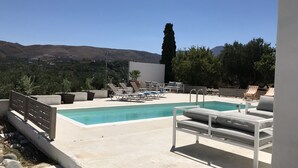 A rooftop pool area with lounge chairs and a view of mountains. - Traditional Stone Villa with Sea Views, Private Pool and 10 mins from beach (Karefiliana)