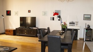 A modern living room with a dining table, chairs, a TV, and a fireplace. - 3 Bedroom Air Conditioned Apartment In The Heart Of Old Town Nice (Nice)