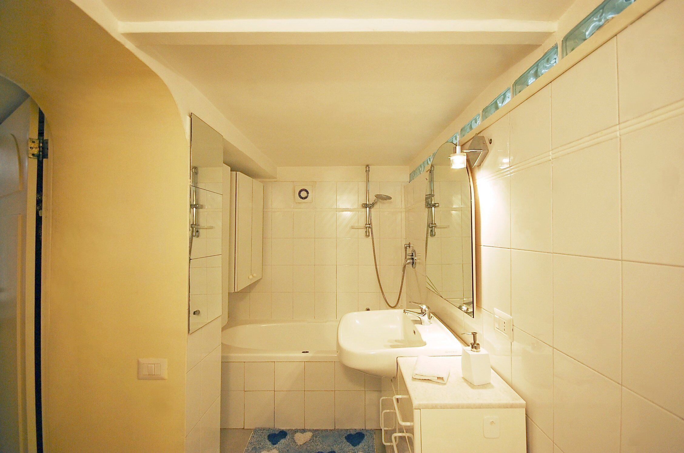 Une salle de bain avec une baignoire, un lavabo et un miroir.