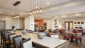 A spacious dining area with multiple tables and chairs, a central light fixture, and a reception area in the background. - Hampton Inn Salt Lake City Cottonwood UT (Salt Lake City)