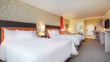 Ett hotellrum med två sängar, ett skrivbord och en TV.