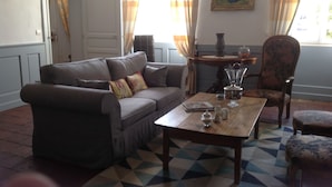 A living room with a brown sofa, a wooden coffee table, and a patterned rug.