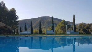 A clear swimming pool with three sun loungers and a mountain backdrop. - Mas del Sord 1335 (L'Albiol)