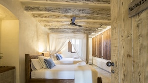 A bedroom with a wooden bed, a ceiling fan, and a wooden door. - Mas del Sord 1335 (L'Albiol)