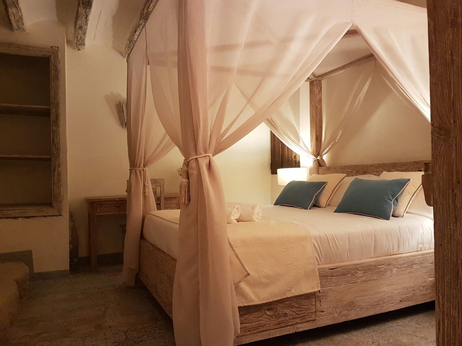 Une chambre à coucher avec un lit à baldaquin, une table de chevet et une commode.